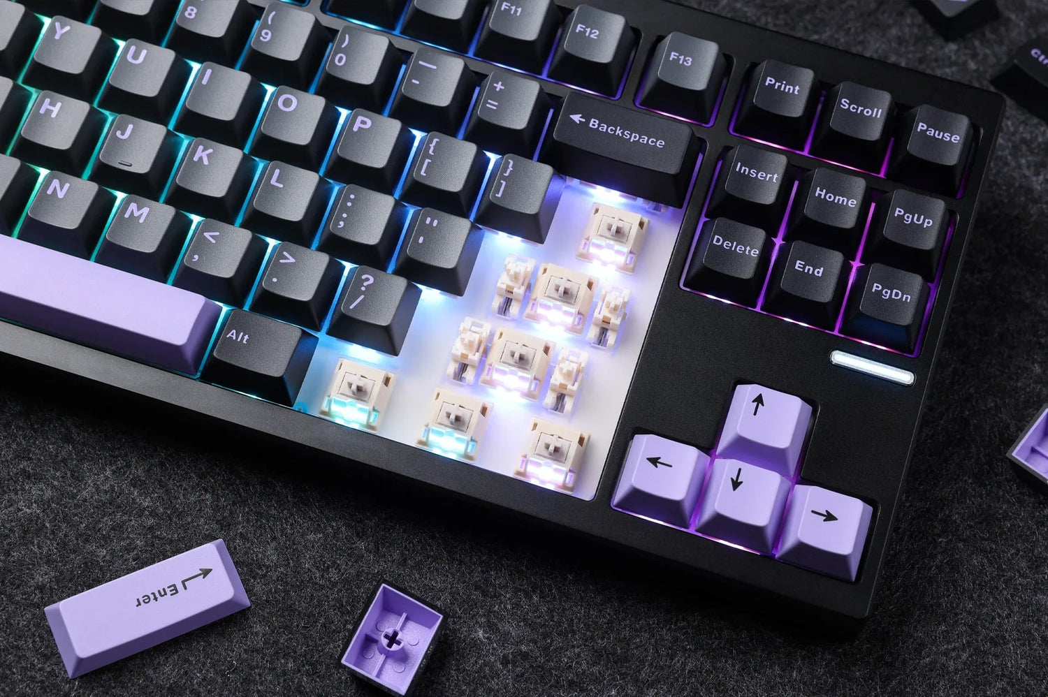 Mechanical keyboard with RGB backlighting, exposed switches, and purple keycaps on dark surface