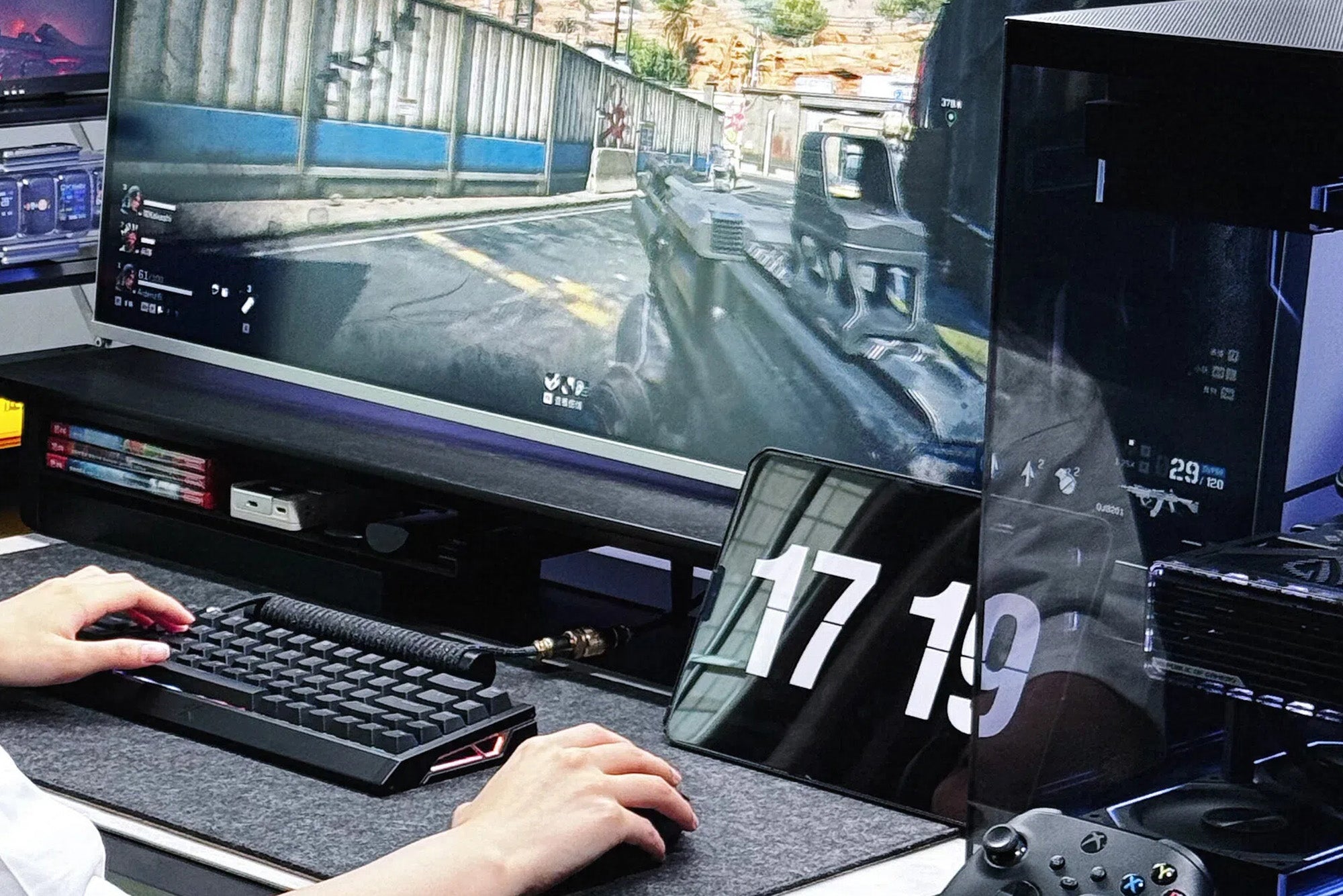 Gaming setup with keyboard, mouse, and monitor displaying first-person shooter game.