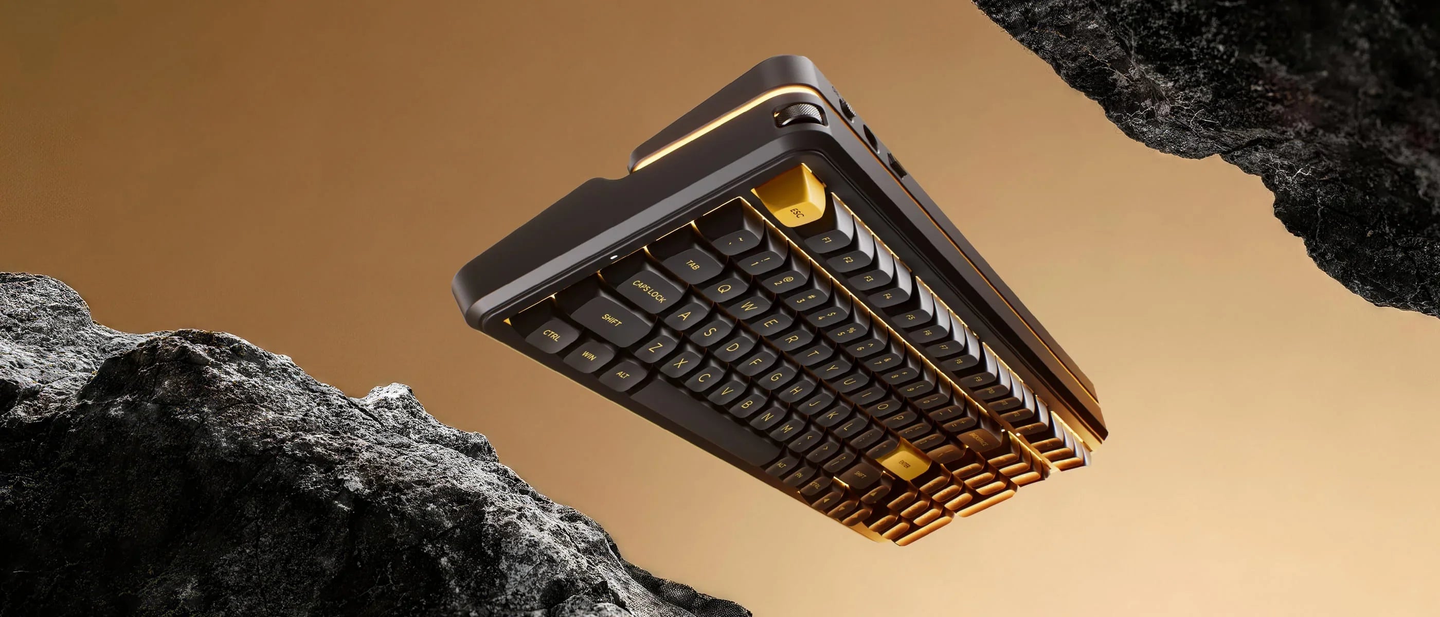 Sleek black and gold mechanical keyboard with glowing edges, floating between rugged rocks against warm backdrop